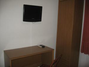 a tv sitting on top of a wooden stand next to a wall at Hostal Fontdemora in Mora la Nueva