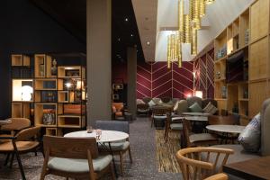 a restaurant with tables and chairs and a chandelier at Ibis Abdelmoumen Casa Centre in Casablanca