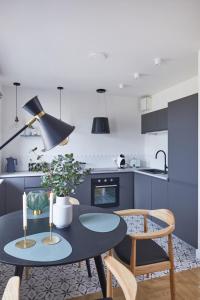 a kitchen with blue cabinets and a table and chairs at Metro Politechnika Studio in Warsaw