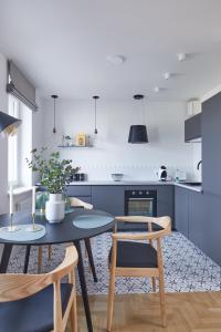 a kitchen with a table and chairs in a kitchen at Metro Politechnika Studio in Warsaw
