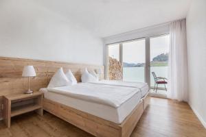 DagmersellenAparthotel Wiggertal - Self Check-in的一间带大床和大窗户的卧室