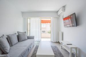a living room with a gray couch and a window at Bright One BDRM Apartment AC-Congress, Beaches by Olidesi in Cannes