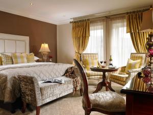 a bedroom with a bed and a chair and a table at Muckross Park Hotel & Spa in Killarney