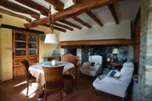 uma sala de jantar com uma mesa e cadeiras num quarto em Turisme Rural Mas Isoles -ZONAS NO COMPARTIDAS- em Ripoll