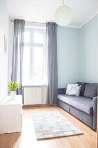 a living room with a couch and a window at AL-DOM apartamenty Apartament Oliwia in Kołobrzeg