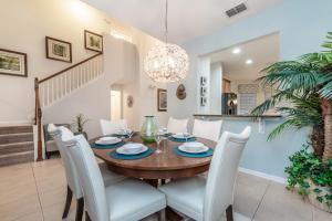a dining room with a table and chairs and a chandelier at Spacious Home wPrivate PoolSpa & FREE Waterpark in Orlando