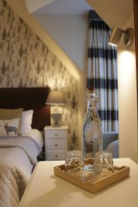 a glass bottle on a table in a bedroom at No12 Hotel in North Berwick