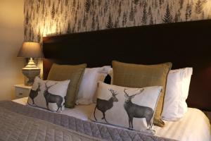 a bed with four pillows with deer on it at No12 Hotel in North Berwick