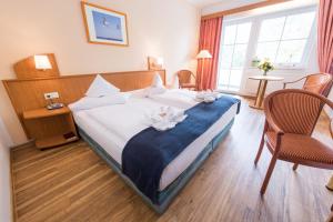 a hotel room with a large bed with a blue blanket at Hotel Ostseewoge in Graal-Müritz