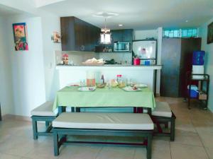 a kitchen with a table and chairs in a room at Acogedor departamento con playa privada in Salinas