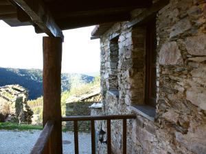 a window of a stone house with a view of a river at Casa Aigra in Góis