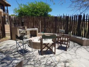a patio with a table and chairs and a fence at Zebula 5 Bedroom, sleeps12 IZN1 in Mabula