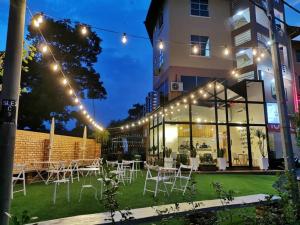 a group of tables and chairs in front of a building at Mass Boutique Hotel in Mentekab