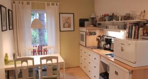 a kitchen with a table and a white refrigerator at Ferienwohnung mit Garten in Berlin