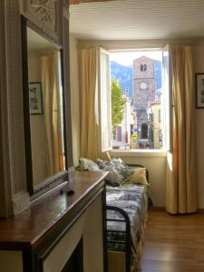 a living room with a mirror and a couch and a window at Chateau View Chambres d'hôtes in Quillan