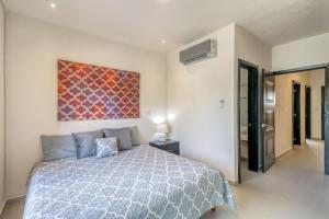 een slaapkamer met een bed en een schilderij aan de muur bij Selvanova Coto 4B, Villa Flamingos 437F in Playa del Carmen +31 foto's