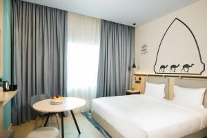 マスカットにあるSwiss-Belinn Airport Muscat Omanのベッドとテーブルが備わるホテルルームです。