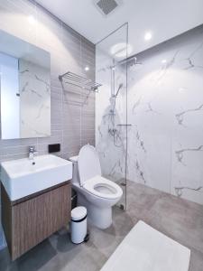 a bathroom with a toilet and a sink and a mirror at SOVA Hotel Bangkok in Bangkok