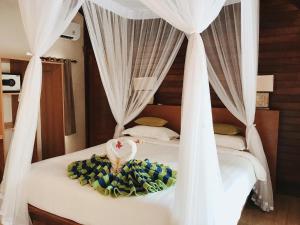 a bedroom with two beds with white drapes at Darsan Lembongan Boutique Cottage in Nusa Lembongan