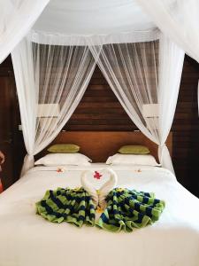 ein Schlafzimmer mit einem Bett mit einer herzförmigen Decke in der Unterkunft Darsan Lembongan Boutique Cottage in Nusa Lembongan
