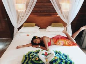 Ein Mädchen auf einem Bett mit einer Herzdecke in der Unterkunft Darsan Lembongan Boutique Cottage in Nusa Lembongan