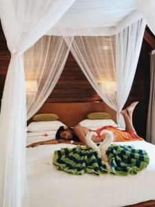 a woman laying on top of two beds at Darsan Lembongan Boutique Cottage in Nusa Lembongan