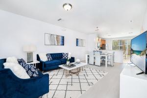 a living room with a blue couch and a table at Updated Vista Cay Townhome, 10 min from Universal in Orlando