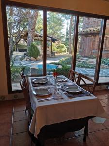 Hostal del Senglar في إسبلوغا دي فرانكولي: طاولة غرفة الطعام عليها مفرش أبيض