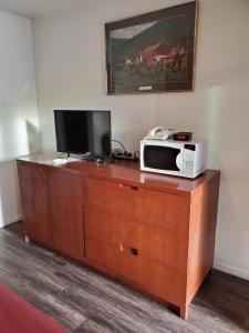 a microwave sitting on top of a dresser with a television at Ontario Inn in Ontario