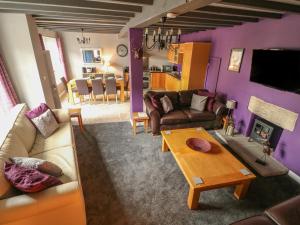 a living room with purple walls and a couch and a table at Royal Oak in Matlock