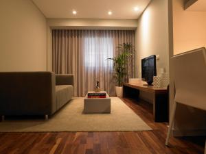a living room with a couch and a television at Altis Prime Hotel in Lisbon