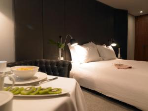 um quarto de hotel com uma cama e um prato de comida numa mesa em Altis Prime Hotel em Lisboa