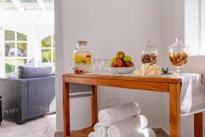 a table with towels and a bowl of fruit on it at Stillness Manor Estate & Spa in Constantia