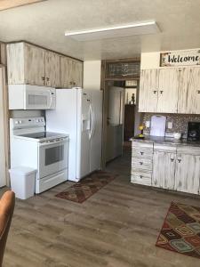 a kitchen with white appliances and wooden cabinets at Dora's Country Cottage in Escalante