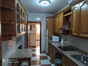 a kitchen with wooden cabinets and a checkered floor at La Casa del Montero in El Pedroso