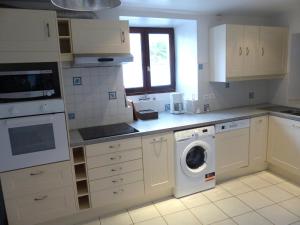 a kitchen with a washer and dryer in it at Le chant des arbres in Bourron-Marlotte