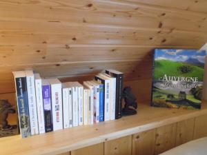 a book shelf with several books on it at Chalet des Clarines in Saint-Genès-Champespe