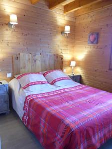 a bedroom with a bed with a red and white blanket at Chalet des Clarines in Saint-Genès-Champespe