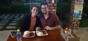 a man and a woman sitting at a table with food at Phong Nha Bolero Bungalow in Phong Nha