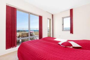 a bedroom with a red bed and a large window at Byala Panorama Resort in Byala +72 photos