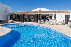 a large blue swimming pool in front of a house at Hotel d'Or in Cala d´Or