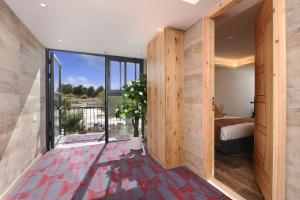 een slaapkamer met een bed en een groot raam bij Tzukim Desert Traveler's Hotel - מלון צוקים in Mitzpe Ramon