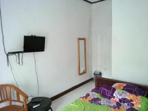a bedroom with a bed and a tv on the wall at Latansa inn in Karimunjawa