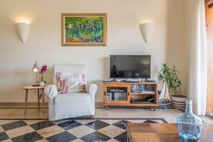 sala de estar con TV y silla en Villa Ambar Cherry, en Playa Blanca