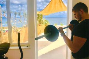 a woman lifting a weight in front of a window at Hotel Casa Rosa Terme in Ischia