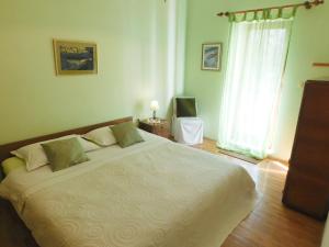 um quarto com uma grande cama branca e uma janela em Villa Kate em Vis