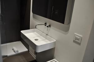 baño con lavabo blanco y TV en la pared en M Suite en San Benedetto del Tronto