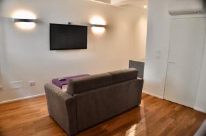 M Suite في سان بنيديتّو ديل ترونتو: غرفة معيشة مع أريكة وتلفزيون بشاشة مسطحة