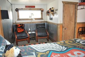 a bedroom with a bed and two chairs and a window at Cowboy Country Inn in Escalante