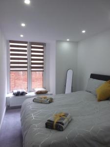 1 dormitorio con 1 cama grande y 2 toallas. en Elm Street Apt with 2 Bed 2 Bathrooms, en Ipswich